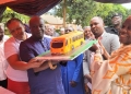 Amb. Walusimbi with Kampala Minister visit the Bakery stall, pause with cake made in NRM bus cake