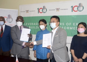 Vice Chancellor of Makerere University Barnabas Nawangwe (2nd L) shakes hands with Zheng Biao (2nd R), a representative of China Enterprises Chamber of Commerce in Uganda, after signing a memorandum of understanding at Makerere University in Kampala, Uganda, on July 21, 2022 (PHOTO /Courtesy)