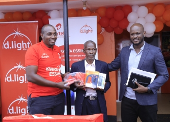 Henry Njoroge (L), Head of Marketing at Airtel Uganda, Douglas Gavala (R), Managing Director at d.light Uganda Limited handing over a gift hamper to Maganda John (C) the first buyer of the smartphone.This was today at the partnership launch between Airtel Uganda and d.light Uganda at Mukono d.light shop.