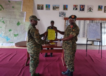 Brig Gen Balikuddembe (C) witnesses Brig Gen Mugisha (L) handing over a report to Brig Gen Busizoori (R)