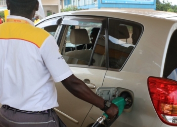 A man fuels a car at a petrol station in Kampala.