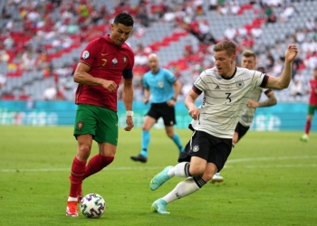 MUNICH, GERMANY - JUNE 19: Cristiano Ronaldo of Portugal runs with the ball whilst under pressure from Marcel Halstenberg of Germany during the UEFA Euro 2020 Championship Group F match between Portugal and Germany at Football Arena Munich on June 19, 2021 in Munich, Germany. (Photo by Matthias Schrader - Pool/Getty Images)
