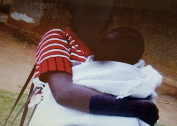 Prisca, 13, a tennage mother holding her baby at Bumoni. David Mafabi