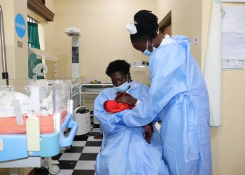 Natukunda being supported by the midwife to breatfeed her baby.