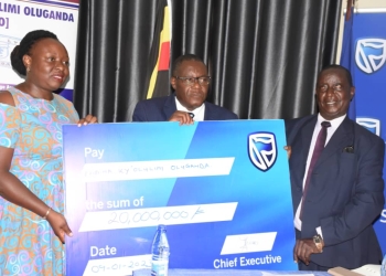 L-R Emma Mugisha, Executive director Stanbic bank, Attorney General Chris Bwanika and Chairman Luganda language Association Fred Kisiriko received a dummy cheque at the press conference yesterday at Bulange.