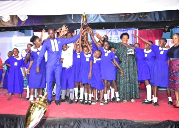 Nakivubo Blue Primary School celebrates with their head teacher and the Director Education and social service on the extreme right.