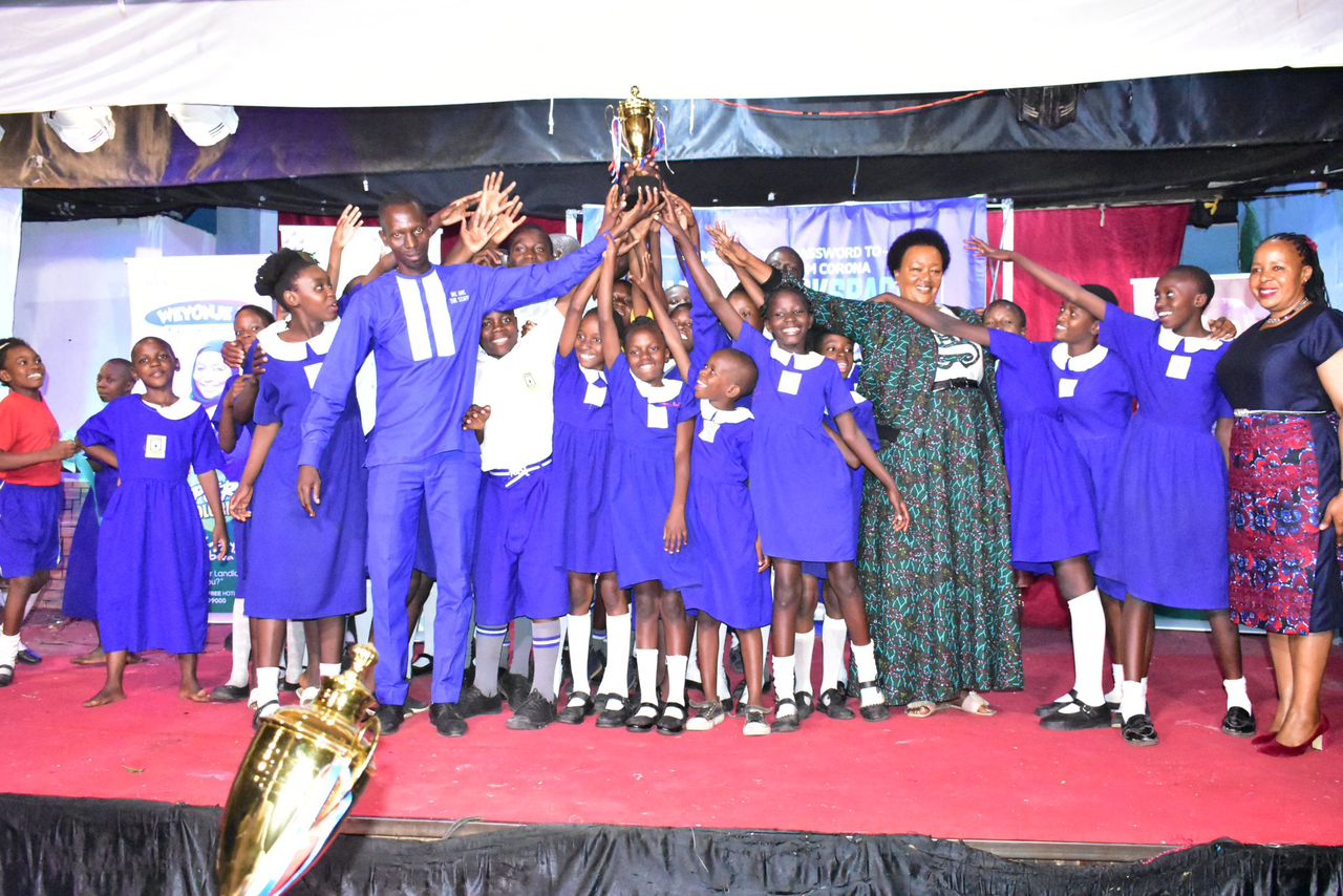 Nakivubo Blue Primary School celebrates with their head teacher and the Director Education and social service on the extreme right.