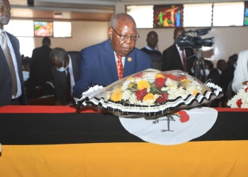 Widower Ambassador Idule Amoko laying a wreath on the fallen Lady Justice's casket