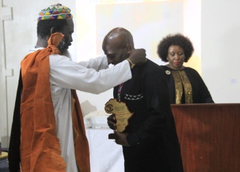 Bishop Joshua Maponga handing over the medal and award to Prof. Muganga on Saturday, August 26