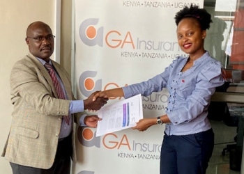 Gordon Asimwe, Marketing Manager GA, Insurance handin over the travel documents to Emily Mahero, the Mayhem Winner at GA Offices.