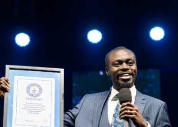 Apostle Grace Lubega displaying a certificate from Guinness Book of records.