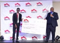 Yunus Mugabe receives a dummy check of USD1000 from MD Equity Anthony Kituuka (PHOTO/Courtesy)