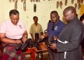 left-right) Presidential Initiative on skilling the Girl/Boy Child (PISGC) head of the project Faith Katana Mirembe, PISGC manager Hillary Musoke Kisanja and All Saits Church Rev. Stephen Lumu admiring shoes made by Students of PISGC at Mutundwe centre this was during the Presidential Initiative on skilling the Girl/Boy Child project 7th intake inspection of the skills of the students as they show case their work at Mutundwe centre on 17th February 2023. Photo by PPU/Tony Rujuta.