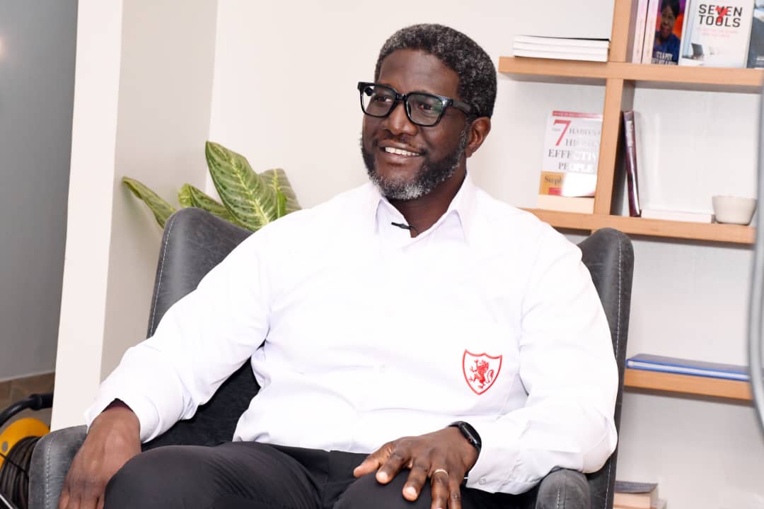 Sam Mwogeza, the Executive head of personal and private banking at Stanbic Bank in a King's College Budo school uniform during the unveiling of the back to school promotion at Stanbic Bank last week.