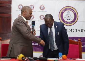 His Lordship Jameson Karemani handing over instruments of power to His Worship James Mawanda Ereemye on Friday. (Photos by Judiciary communications team)