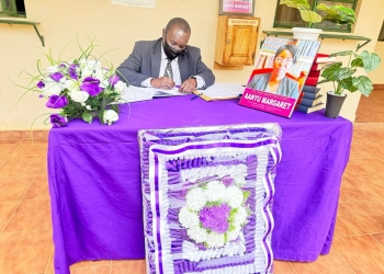 Justice Henry Peter Adonyo signing in the condolence book