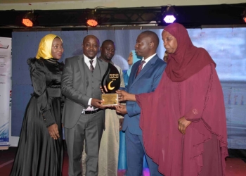 Minsiter David Bahati (2nd right) handing over the award to management of Kamoga Property consultants on Friday evening.