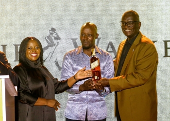 L-R - UBL Board Member Racheal Dumba and UBL Managing Director Andrew Kilonzo gifting the President of the Uganda Golf Union Moses Matsiko with a personalised Johnnie Walker bottle