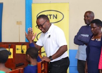 Brian Mbasa, Senior Manager MTN Foundation talks to learners of Hornby High School Junior as they use computers courtesy of the telecom company to stir digital skills among learners (PHOTO/Courtesy)