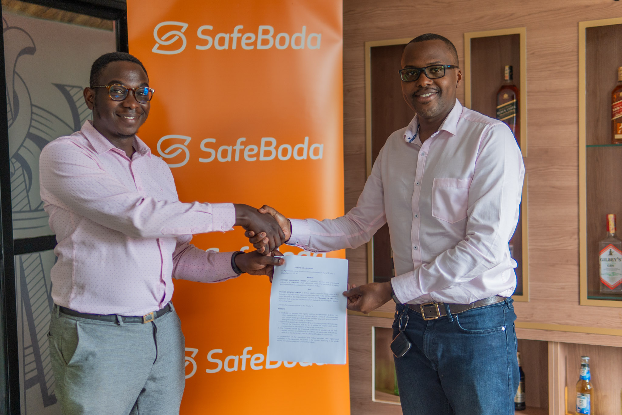 Christian Wamambe – Vice President of Payments at SafeBoda (L) and Emmy Hashakimana - UBL's Commercial Director (R) pose for a picture after the MoU signing.