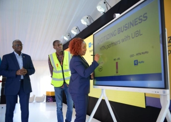 MTN Uganda CEO Sylvia Mulinge appends a digital signature to mark the launch of FMCG Digital Suite at Uganda Breweries Ltd on July 14. Looking on is UBL MD Andrew Kilonzo.