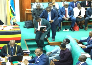 Joel Ssenyonyi is "dragged" to his seat by Hon. Francis Mwijukye after Speaker Among announced the changes in the Opposition ranks