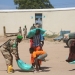 A Djibouti peacekeeper assists a man and a boy carry a bag of rice during a food donation exercise conducted by ATMIS Djibouti soldiers in Bulobarde, Galgaduud region of Somalia on 4 January 2024.