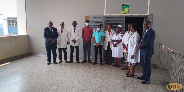 The donor and the recipient wearing red and blue shirts standing with transplant surgeons at Mulago Hospital. (PHOTO/URN)