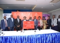 UCC Executive Director, Hon. George William Nyombi Thembo (5th L), receiving a dummy cheque worth UGX 34.6 Billion from Airtel Uganda Managing Director, manoj murali (4th L) joined by other officials from Airtel Uganda and UCC during a press event where Airtel Uganda announced its payment of UGX 34.6 Billion Uganda to UCC to Support Rural Communications Infrastructure Development. This was at UCC head Offices today, 4th April 2024.