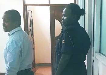 Businessman Musa Ssenteza (center) being escorted by prison authorities to the Kampala Central Prison on May 13, 2024, after being remanded by the Anti-Corruption Court for forgery and tax evasion charges (PHOTO/URA)