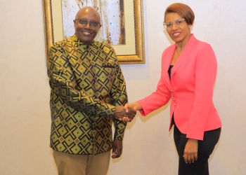 Ambassador Richard Kabonero, Head of Regional Economic Cooperation, and Lilly Ajarova, CEO of Uganda Tourism Board (UTB), shake hands during a joint regional economic and commercial diplomacy retreat. The two leaders discussed ways to leverage Uganda's missions abroad to boost tourism and attract investments, with a focus on promoting economic growth and development in the region.