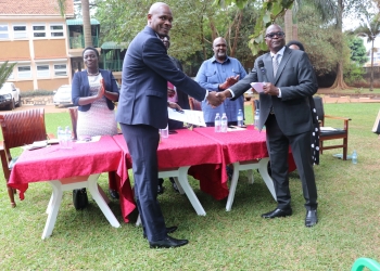 Outgoing Executive Director Tom Obong Okello (right) hands over the tools of office to incoming Acting Executive Director Stuart Maniraguha (left) at the National Forest Authority (NFA) ceremony, marking a new chapter in the organization's journey.