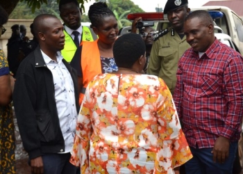 Nabbanja , the Prime Minister (with back) interacts with Erias Lukwago the Lord Mayor of Kampala (right) and other officials during the tragedy site inspection