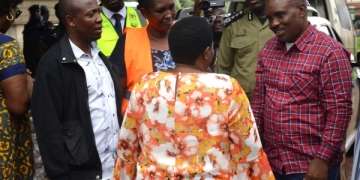 Nabbanja , the Prime Minister (with back) interacts with Erias Lukwago the Lord Mayor of Kampala (right) and other officials during the tragedy site inspection