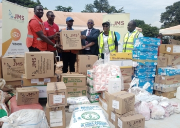 Dr. Bildard Baguma, the Executive Director of Joint Medical Store handing over the donation to Redcross team at Kiteezi.