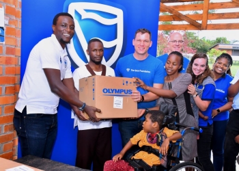 Tich Makonese, the Stanbic Bank Head of Insurance handing over the part of assortment to the Gem Foundation team.