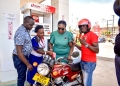Airtel Money's Hope Ekudu (left) fuels up a lucky winner's motorbike in the Vroomula Amajja campaign, celebrating the launch of Airtel Money's partnership with Stabex International to drive cashless transactions and digital financial inclusion in Uganda