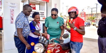 Airtel Money's Hope Ekudu (left) fuels up a lucky winner's motorbike in the Vroomula Amajja campaign, celebrating the launch of Airtel Money's partnership with Stabex International to drive cashless transactions and digital financial inclusion in Uganda
