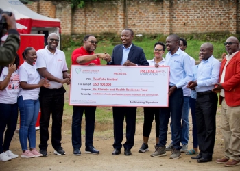Tetteh Ayitevie, CEO Prudential Uganda and Stanley Banyoole, Resident City Commissioner (RCC), Fort Portal City handing over a dummy cheque of USD 100,000 to Henry Othieno, Team Lead, Tusafishe Limited during the launch of the safe water project at Mpanga Secondary School.