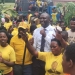 Supporters donning yellow T-shirts gather around Hon. Cadet in Rubirizi, waving and chanting as they welcome President Museveni during his PDM tour. The vibrant crowd reflects strong grassroots mobilization and community enthusiasm.