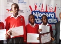 Some of the best students at Primary level displaying their certificates.