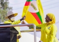 NRM's Faridah Nambi Kigongo receiving the Party flag from National Chairman, President Yoweri Kaguta Museveni, during his visit to Kawempe. (courtesy photo)