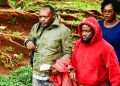 D/ASP Charles Twine (in army green jacket) with Noah Mutwe arriving at Buganda Road court on Thursday. (Courtesy photo)