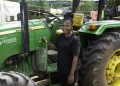 Felicia Mbaidooue Gbuuka, 35, stands beside her tractor at her home in Yagba community, Nigeria on June 25, 2023.