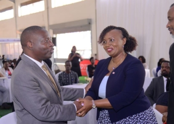 Minister David Bahati (left) chats with Irene Mutyaba Kabiri, the Corporate Banking Director at Absa Bank Uganda during the UMA 2nd Financial Symposium. Looking on is Dr. Ezra Muhumuza Rubanda, the UMA Executive Director