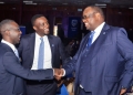 Mumba Kalifungwa (R), Stanbic Bank Chief Executive shaking hands with Ronald Makata, bank's Chief Finance Officer, Looking on is Tich Makonese, the Stanbic Head Bankassurance