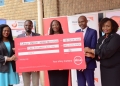 Absa Bank Uganda officials present UGX 100 million to World Vision representatives.