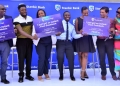 Dan Atuhairwe, the Flexipay Product Lead, Mellisa Nyakwera, Head Commercial Banking, Stanbic and Saurabh Jain the Boda Banja Chief Operations Officer pose for a photo with campaign influencers during the launch in Kampala
