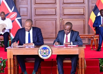 Uganda Investment Authorityu's Director General Robert Mukiza and his Kenyan counterpart signing an MOU on Investment promotions at Nairobi State house on Wednesday as Presidents Museveni (L) and Ruto (R) l