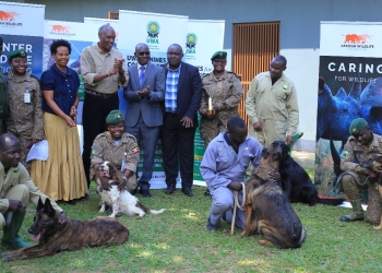 Some of the dog handlers with their dogs and other stakeholders during the hand over ceremony in Entebbe on Tuesday.